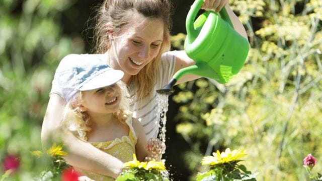 Mother and daughter watering flowers